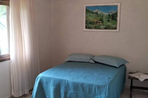 a bedroom with a bed with a blue blanket at Sítio Som das Águas in Benedito Novo