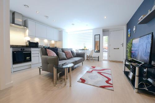 sala de estar con sofá y TV y cocina en Ground Floor One Bedroom Flat Centre of Woking with Off Street Parking, en Woking