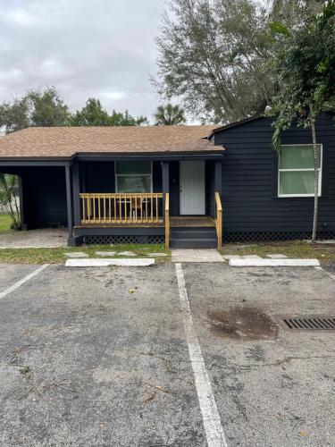 a blue house with a porch and a driveway at City First Story Apartments & Cottage in Fort Lauderdale