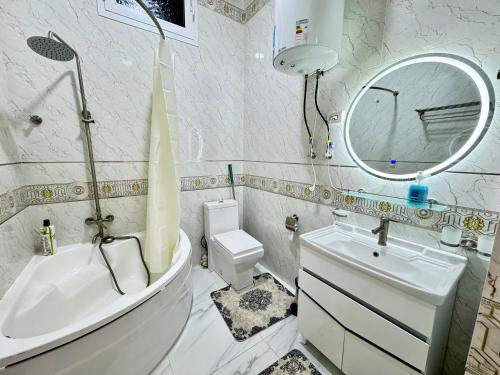 een badkamer met een wastafel, een toilet en een spiegel bij Samarkand luxury apartament #8 in Samarkand