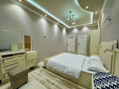 um quarto com uma cama, uma cómoda e uma televisão em Samarkand luxury apartament #8 em Samarkand