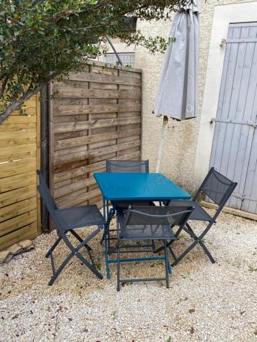 - une table de pique-nique, 2 chaises et un parasol dans l'établissement Maison résidence Odalys, à Calvisson