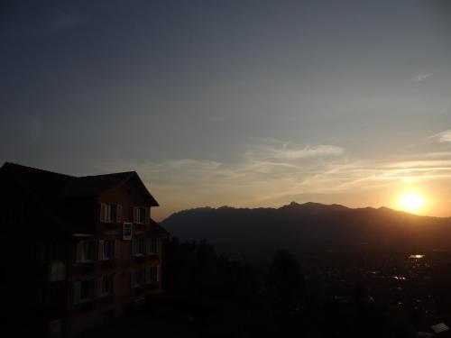 a sunset over a city with a building in the foreground at Waldrast Bed & Breakfast in Batschuns