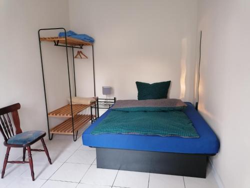 - une chambre avec un lit bleu et une chaise dans l'établissement FEWO Civrilli 5 Zi/Wohnung, à Teuchern