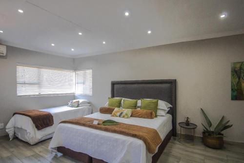 a bedroom with two beds and a window at Apartment at Magalies Edge in Hartbeespoort