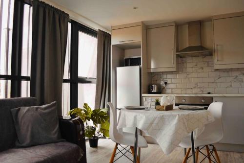 a kitchen with a table with chairs and a refrigerator at Shoreditch / Brick Lane - Studio in London