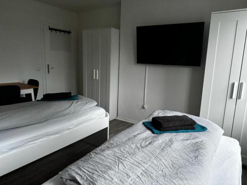 a bedroom with two beds and a flat screen tv at 5-Bett Wohnung im Boardinghaus Elisabeth in Dinslaken