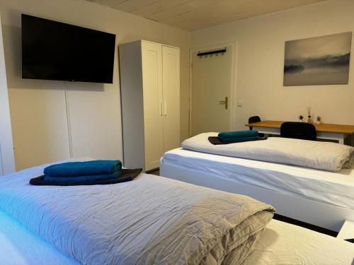 two beds in a room with a flat screen tv at 5-Bett Wohnung im Boardinghaus Elisabeth in Dinslaken