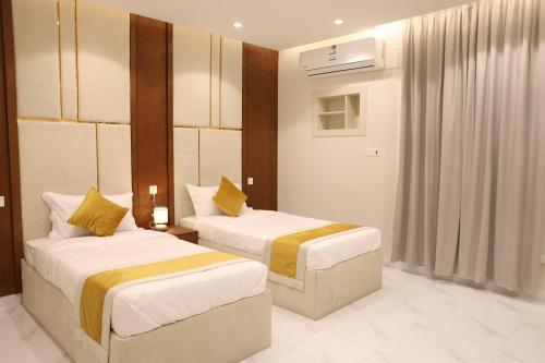 a hotel room with two beds in a room at جوهرة دومة الجندل للشقق المخدومة Jawharat Dumat Serviced Apartments in Dawmat al Jandal