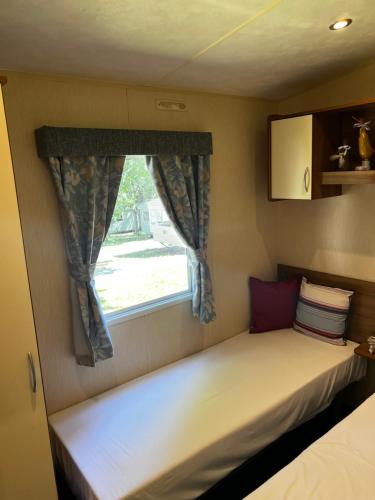 a small bed in a room with a window at Sea View, Thorness Bay in Porchfield