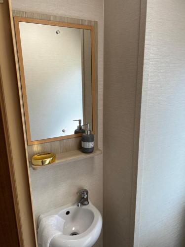 een badkamer met een wastafel en een spiegel bij Sea View, Thorness Bay in Porchfield