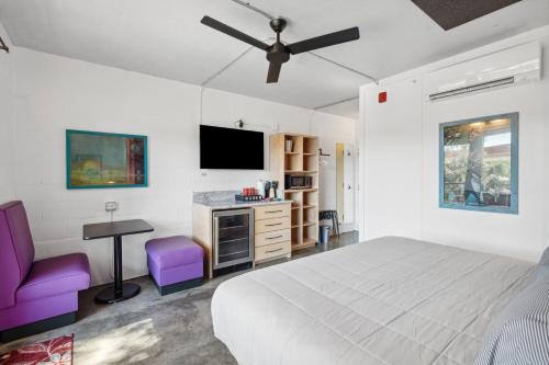 a bedroom with a bed and a desk and a tv at Boutique Vera Hotel in the Heart of Folly Beach in Folly Beach