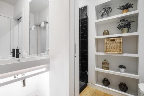 a white bathroom with a sink and a mirror at WHome Urban Elegance: A Modern Haven in Lisbon's Heart in Lisbon