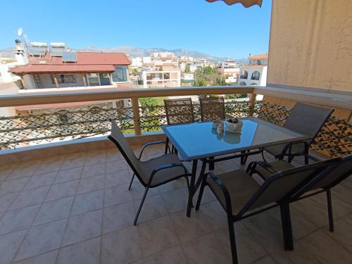a table and chairs on a balcony with a view at NEW elegant roof apartment in Acharnes