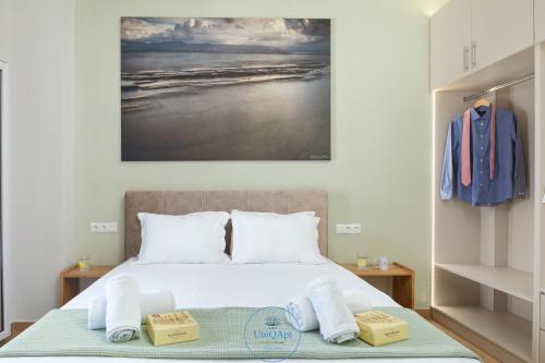1 dormitorio con 1 cama con toallas en UniQApt Garitsa Woods, en Corfú