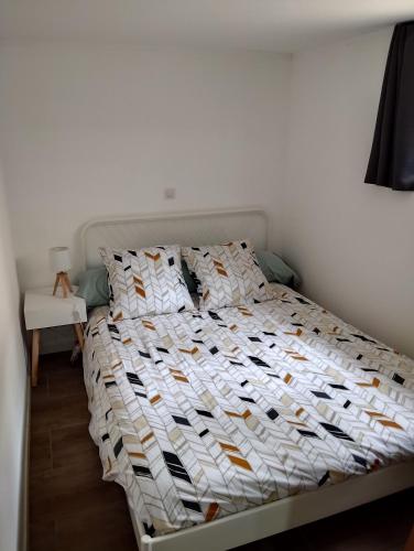 una camera da letto con un letto con un piumone bianco di Appartement Noméo a Saint-Privat-des-Vieux