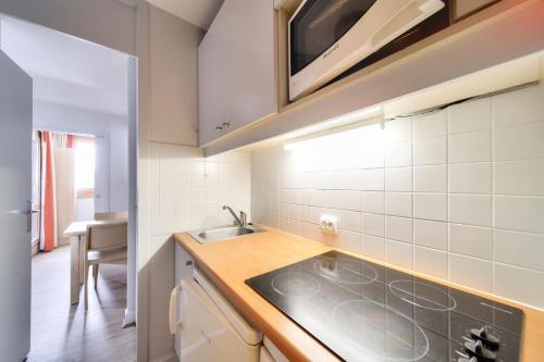 une cuisine avec un évier et un plan de travail dans l'établissement Résidence Plagne Lauze - maeva Home - Studio 4 personnes - Prestige MAE-1944, à Mâcot La Plagne