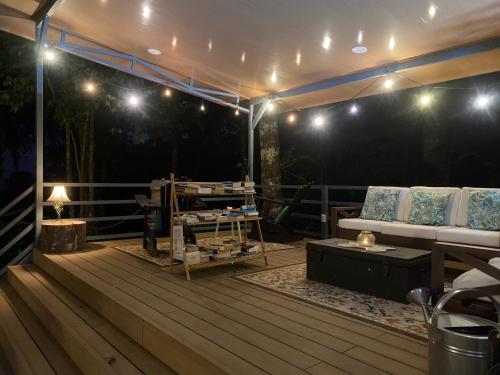 a deck with a couch and a table and lights at Villas en el Bosque in Ojochal
