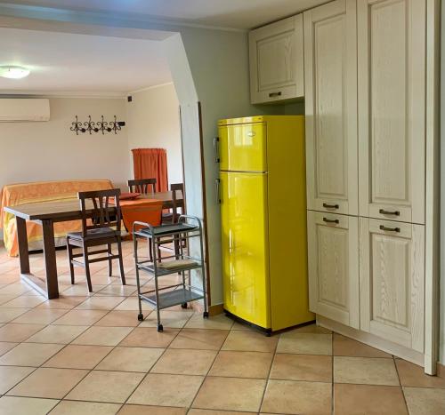 una cucina con frigorifero giallo e tavolo con sedie di Marvi House a Morciano di Romagna