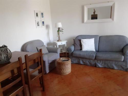 - un salon avec un canapé et une chaise dans l'établissement Casa i Quattro Alberi, à Montemiletto