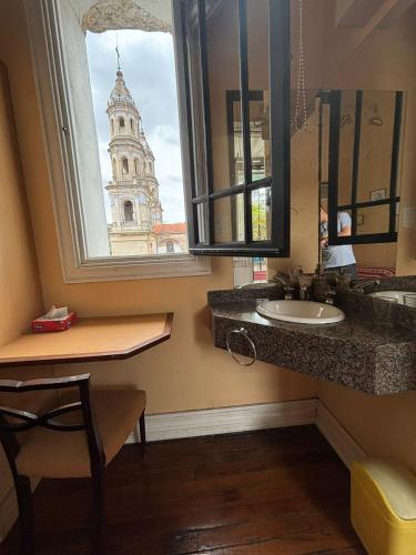 a bathroom with a sink and a window with a tower at LGY Bed & Breakfast ONLY MEN-SOLO HOMBRES in Buenos Aires