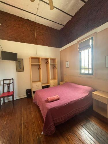 a bedroom with a pink bed and a window at LGY Bed & Breakfast ONLY MEN-SOLO HOMBRES in Buenos Aires