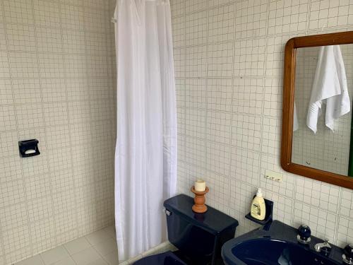 パイパにあるCasa Loma - Ubicada en un bosque de eucaliptos entre Paipa y Duitamaのバスルーム(白いシャワーカーテン、青いトイレ付)