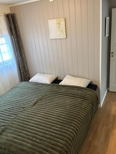 a bed in a room with a striped wall at B&B i flott utsiktseiendom Otta in Otta