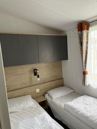 a room with two beds and a window in it at Lean into the Gardens of Heligan in St Austell