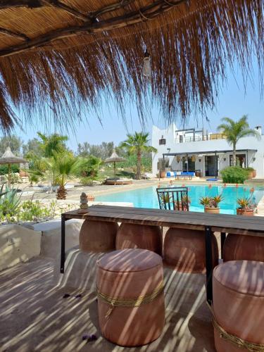 a resort with a table and chairs and a swimming pool at Les jardins de Silona in Essaouira