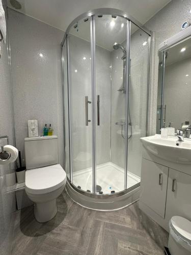 a bathroom with a shower and a toilet and a sink at Shipping Lanes Hotel in Morecambe