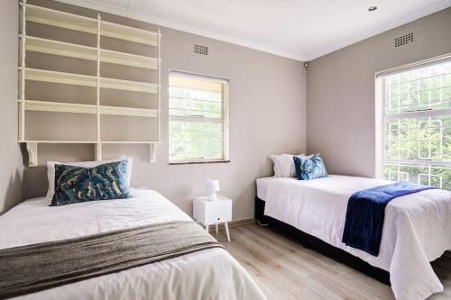 um quarto com 2 camas e uma janela em The Hide Out - Home away from home em Joanesburgo