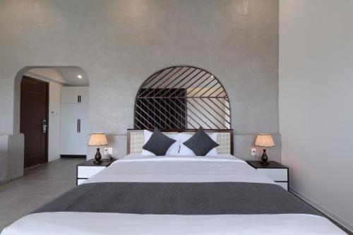 a bedroom with a large bed with two lamps at Charm Champion Villa Hoian in Hoi An