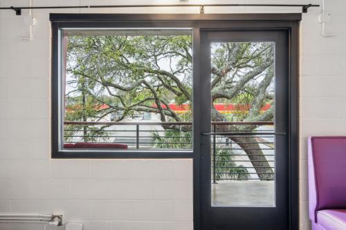 a window in a room with a tree outside at Boutique Vera Hotel in the Heart of Folly Beach in Folly Beach
