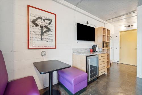 a room with a table and a purple stool at Boutique Vera Hotel in the Heart of Folly Beach in Folly Beach