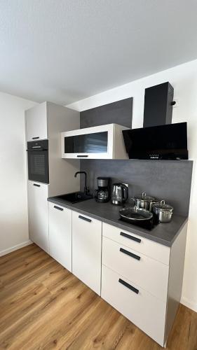 a kitchen with white cabinets and a black counter top at Casa Estella in Rust
