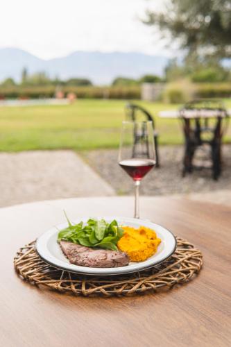 a plate of food and a glass of wine on a table at El Porvenir Wine Lodge in Cafayate