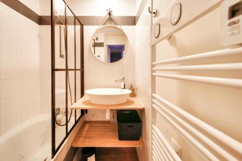 een badkamer met een wastafel, een bad en een spiegel bij Résidence Plagne Lauze - maeva Home - Studio 4 personnes - Sélection 804 in Mâcot La Plagne
