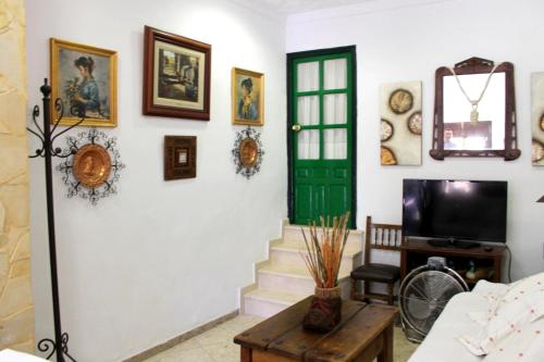 a living room with a green door and pictures on the wall at Typical Andalusian house in the center of Ronda / Casa típica andaluza en el centro de Ronda. in Ronda