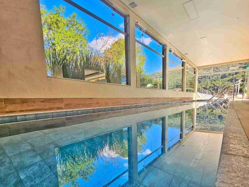 uma piscina interior com vista para a água em Hotel Zanon em Águas de Lindoia