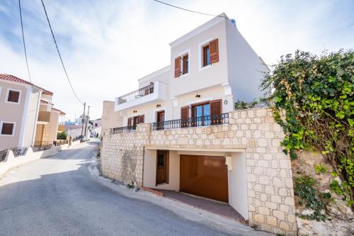 a white house with a garage on a street at Villa Danai in Karpathos Town