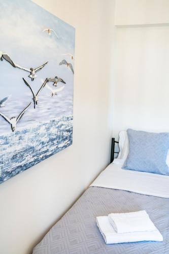 a bedroom with a bed with a painting on the wall at Villa Danai in Karpathos Town