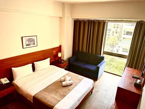 1 dormitorio con 1 cama, 1 silla y 1 ventana en Caesar's Park Hotel, en Beirut