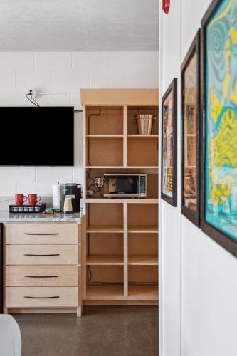 a kitchen with a cabinet with a microwave and a tv at Boutique Vera Hotel in the Heart of Folly Beach in Folly Beach