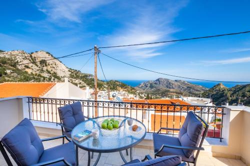 a balcony with a table and chairs with a view of the ocean at Villa Danai in Karpathos Town