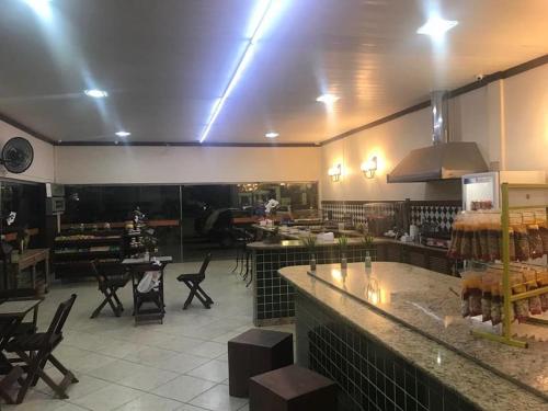 a restaurant with a bar and tables and chairs at Pousada Elefantinho in São Pedro da Aldeia