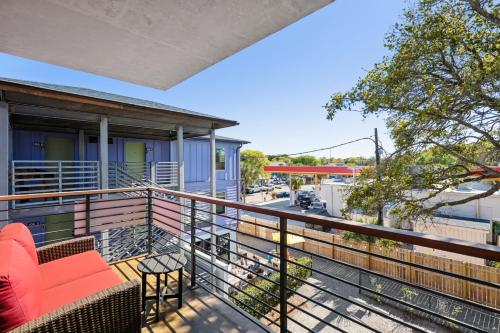 a balcony with red furniture and a view of a street at Boutique Vera Hotel in the Heart of Folly Beach in Folly Beach