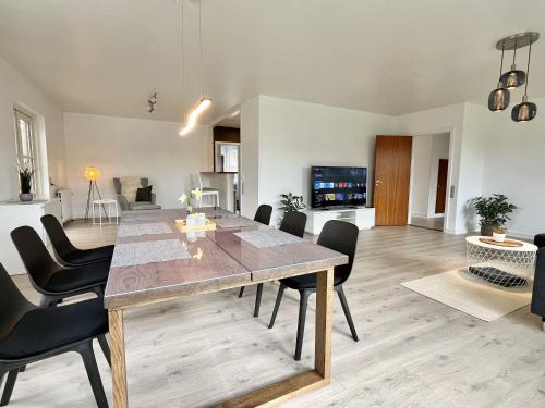 a dining room and living room with a table and chairs at Stunning & Renovated 130sqm Villa only 5 min by car from sandy beaches in Åkirkeby