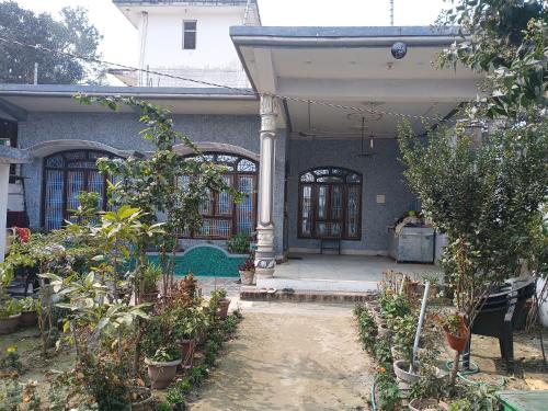 una casa con un porche con un montón de plantas en ARVINDAM VILLA HOMESTAY-THE ESSENCE OF RAMA, en Ayodhya