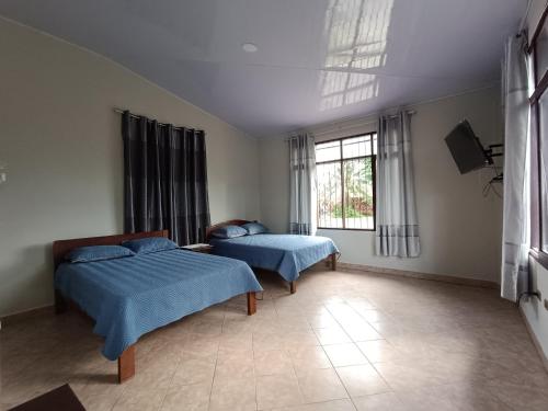 1 dormitorio con 2 camas y ventana en Casa de huespedes con piscina privada en Villa Tunari
